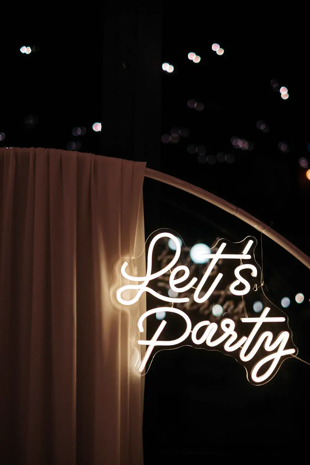 Insegna al neon Let's Party a una festa serale a Villa Balbiano