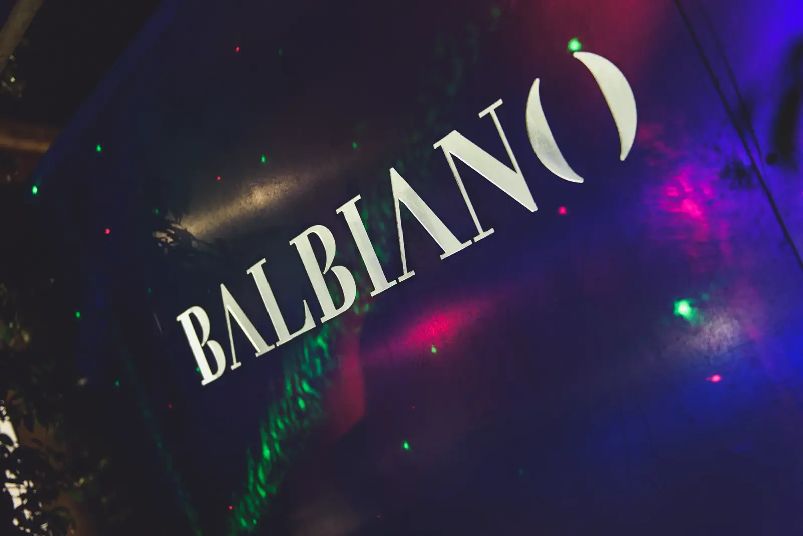 Insegna Balbiano illuminata dalle luci laser durante una festa serale
